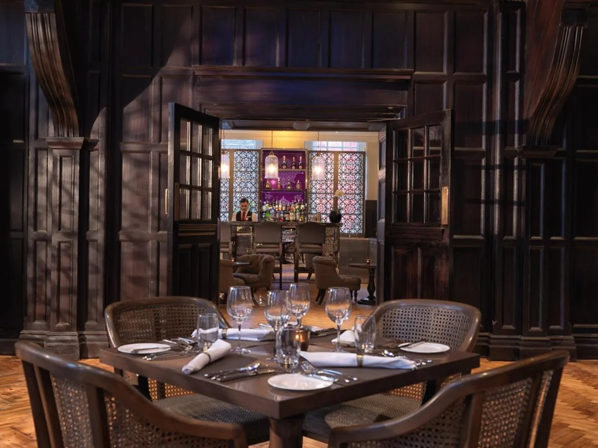 Dining room with bar and tables at The LaLit London restaurant
