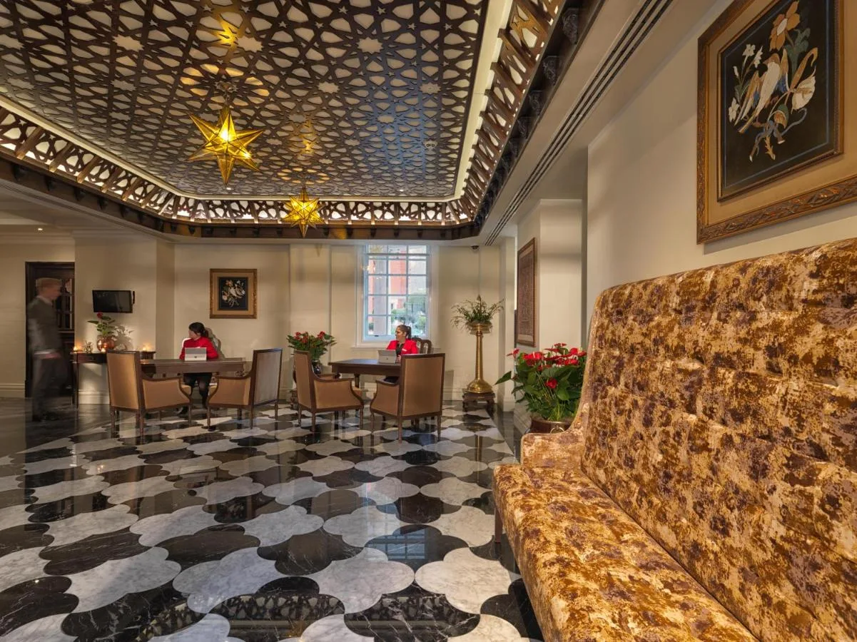 Hotel lobby with couch and guests seated at tables, The LaLit London